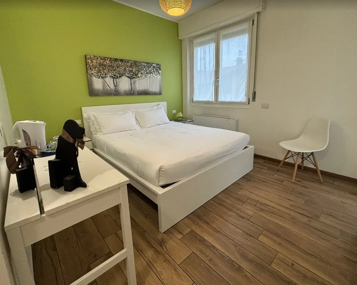 Una camera del Blue con letto matrimoniale e parete verde