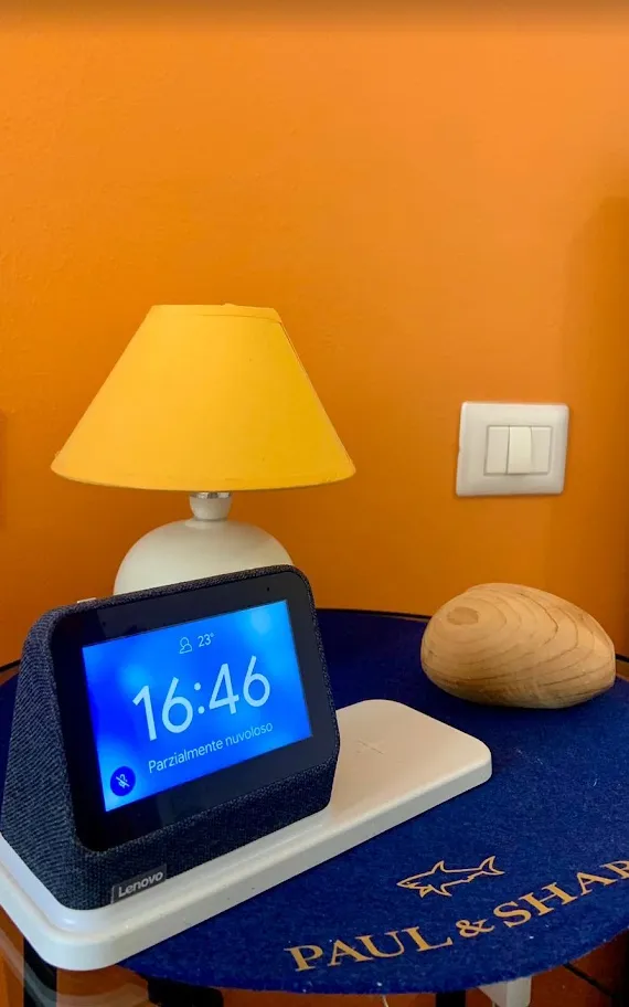 Il comodino con la lampada gialla e la sveglia